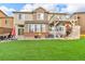 Spacious backyard with manicured lawn, patio, and deck with stairs on a two-story home at 3745 Spanish Oaks Trl, Castle Rock, CO 80108