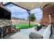 Covered patio includes a stone fireplace, outdoor seating, and views of the expansive backyard at 3745 Spanish Oaks Trl, Castle Rock, CO 80108