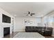 Comfortable living room with gray sectional couch, fireplace, ceiling fan, and large windows at 3745 Spanish Oaks Trl, Castle Rock, CO 80108