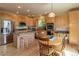 Eat-in kitchen features stainless appliances, wood cabinets, and island with seating at 9586 W Victoria Dr, Littleton, CO 80128