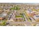 A street aerial view shows property near a school and busy street, with a skyline in the background at 4201 Shoshone St, Denver, CO 80211
