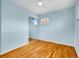 Bright bedroom showcasing hardwood floors, dual windows, and closet with mirrored sliding doors at 4201 Shoshone St, Denver, CO 80211