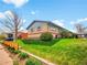 Brick exterior, green lawn, and lush landscaping with a For Sale sign visible from street at 4201 Shoshone St, Denver, CO 80211