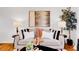 Cozy living room featuring a plush gray sofa, decorative pillows, lamps, and a captivating art piece at 4201 Shoshone St, Denver, CO 80211