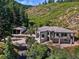 Stunning mountain home with a large deck and a detached garage surrounded by lush greenery at 6123 Buffalo Run, Littleton, CO 80125