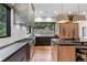 Modern kitchen featuring stainless steel appliances, dark cabinets, and large window with lush greenery view at 6123 Buffalo Run, Littleton, CO 80125