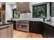 Contemporary kitchen boasts stainless steel range, granite countertops, and views of lush greenery from the windows at 6123 Buffalo Run, Littleton, CO 80125