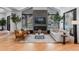 Bright living room features a fireplace, hardwood floors, modern furniture, and ample natural light from expansive windows at 6123 Buffalo Run, Littleton, CO 80125