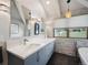 Well-lit bathroom featuring double sinks, stone accent wall, and picture windows overlooking nature at 24172 Jerome Ct, Golden, CO 80401