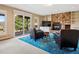 Carpeted basement living room with a stone fireplace and sliding glass doors leading to a backyard patio at 24172 Jerome Ct, Golden, CO 80401