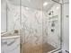 Gorgeous walk-in shower featuring marble look ceramic tile, a pebble floor and built-in shelving at 24172 Jerome Ct, Golden, CO 80401