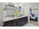Modern bathroom featuring a double sink vanity and large mirror with a peek into the bedroom at 2248 S Lincoln St, Denver, CO 80210