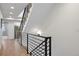 Hallway with metal railing and light wood floors leading up stairs at 2248 S Lincoln St, Denver, CO 80210