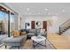 Bright living room with an outside patio, grey sectional sofa, hardwood floors, and view to the modern staircase at 2248 S Lincoln St, Denver, CO 80210