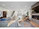 Bright open-concept living area with hardwood floors, modern fireplace, large windows, and views of the kitchen at 2248 S Lincoln St, Denver, CO 80210
