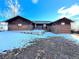 Brick ranch home with a spacious backyard, partially covered in snow at 6861 Oberon Rd, Arvada, CO 80004