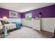This bright bedroom features eye-catching purple walls, a window and white wainscoting at 3285 W 11Th Avenue Ct, Broomfield, CO 80020