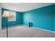 A bedroom features neutral carpeting, bright teal walls and a window with natural light at 3285 W 11Th Avenue Ct, Broomfield, CO 80020