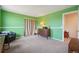Bedroom with muted green walls and carpet offers a view into more of the house at 3285 W 11Th Avenue Ct, Broomfield, CO 80020