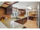 Kitchen featuring a breakfast bar with granite countertops and dark wood cabinets at 3285 W 11Th Avenue Ct, Broomfield, CO 80020