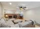 Cozy living room with brick fireplace and plush sectional sofa under a decorative ceiling fan at 3285 W 11Th Avenue Ct, Broomfield, CO 80020