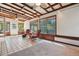 Bright sun room with tile flooring, wood-beam ceiling, and multiple windows offering scenic views at 3285 W 11Th Avenue Ct, Broomfield, CO 80020