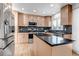 Open kitchen featuring light wood cabinets, granite countertops, stainless appliances, and a functional center island at 9745 Merimbula St, Highlands Ranch, CO 80130