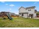 Large backyard with green grass, patio, play set, and playhouse attached to the house at 3495 Amber Sun Cir, Castle Rock, CO 80108