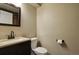 Well-lit bathroom features a vanity with dark cabinets, a toilet, and a mirror at 3495 Amber Sun Cir, Castle Rock, CO 80108