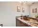 Elegant powder room featuring a copper sink, granite countertops, and decorative wall art at 17509 E Kenyon Dr, Aurora, CO 80013