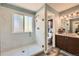 Bathroom with glass enclosed shower, wood-look tile floor, and wood vanity with plenty of storage at 17509 E Kenyon Dr, Aurora, CO 80013