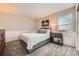 Bedroom featuring a neutral color palette and updated furniture including a queen bed and a side table at 17509 E Kenyon Dr, Aurora, CO 80013