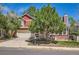 Charming two-story red home featuring brick accents, a well-manicured lawn, and a large tree at 17509 E Kenyon Dr, Aurora, CO 80013