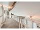 Bright hallway with carpeted floors and a white wood banister overlooking the stairs and front door at 17509 E Kenyon Dr, Aurora, CO 80013