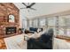 Cozy living room with a brick fireplace, vaulted ceilings, and large windows at 17509 E Kenyon Dr, Aurora, CO 80013