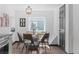 Well-lit dining room boasts modern light fixture and stylish chairs surrounding a glass-top table at 3275 W Hawthorne Pl, Denver, CO 80221