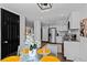 Open-concept dining area leads to a modern kitchen with stainless steel appliances and white cabinetry at 3275 W Hawthorne Pl, Denver, CO 80221