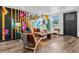 Modern living room featuring a vibrant mural, wood floors, and ample natural light at 3275 W Hawthorne Pl, Denver, CO 80221