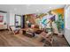 Cozy living room with an artistic mural, hardwood floors, and modern décor at 3275 W Hawthorne Pl, Denver, CO 80221