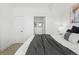 Neutral bedroom with a gray throw blanket on the bed shows the bathroom entrance and a side table at 3040 Wilson Ct # 2, Denver, CO 80205