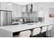 Modern kitchen with stainless steel appliances, sleek white cabinets, and a spacious island with bar seating at 3040 Wilson Ct # 2, Denver, CO 80205