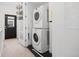 Laundry area features stacked washer and dryer and storage baskets located near a black-trimmed exterior door at 3040 Wilson Ct # 2, Denver, CO 80205
