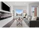 Inviting living room with electric fireplace, large windows offering neighborhood views, and a comfortable gray sofa at 3040 Wilson Ct # 2, Denver, CO 80205