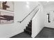 Modern stairwell features dark wood steps, a handrail, art, and tile flooring leading to a frosted door at 3040 Wilson Ct # 2, Denver, CO 80205