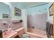 Pastel-themed bathroom featuring matching pink bathtub, sink, toilet, and gray tiled walls at 1175 N Emerson St # 312, Denver, CO 80218