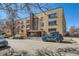 Apartment building exterior featuring brick facade, and parked cars in front at 1175 N Emerson St # 312, Denver, CO 80218