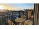 A cozy balcony with a bistro set offers stunning views of the city skyline at sunset at 925 N Lincoln St # 14C, Denver, CO 80203