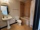 This bathroom features a pedestal sink, toilet, and a bathtub with light brown tiles around the tub at 925 N Lincoln St # 14C, Denver, CO 80203