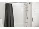 White tiled shower and tub with shower curtain at 3100 Huron St # 1B, Denver, CO 80202