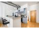 Open kitchen featuring stainless appliances, gray cabinets, granite counters, and wood floors at 3100 Huron St # 1B, Denver, CO 80202